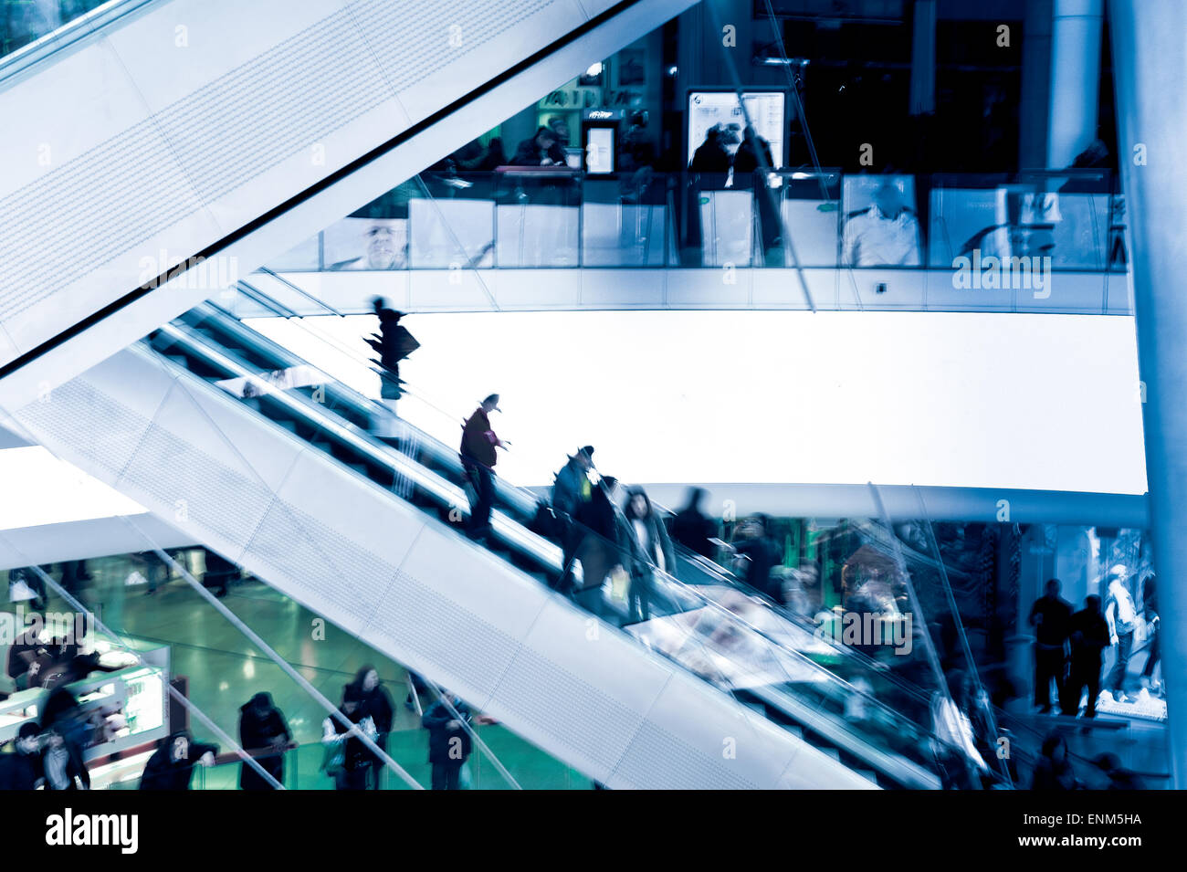 Menschen auf Kreuzung Rolltreppen, blau getönt Stockfoto