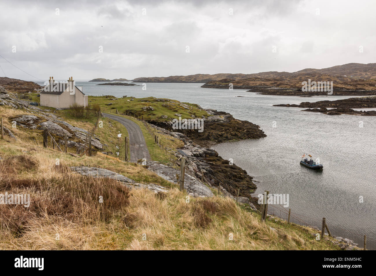 Ein Haus mit Blick auf eine Bucht auf der Insel Harris mit einer Jolle in der Bucht Stockfoto