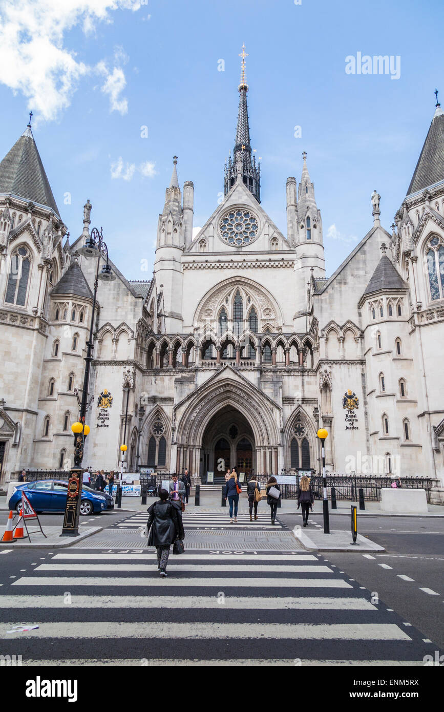Eingang und Außenseite des Royal Courts of Justice (Justizpalast), Strand, London WC2 und Fußgänger Zebrastreifen an einem sonnigen Tag mit blauem Himmel Stockfoto
