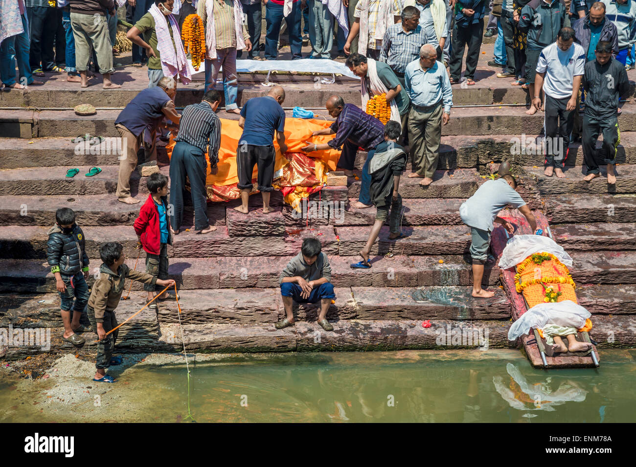 Pashupatinath Tempel in Kathmandu. Eine Leiche wird von einem Verwandten gewaschen. Stockfoto