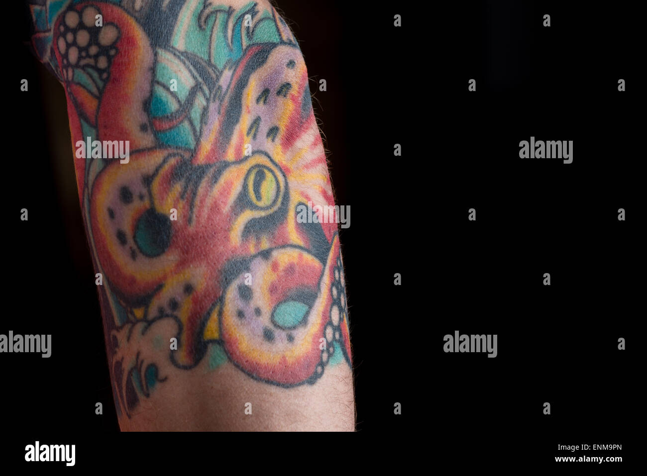 Ein Tattoo von einem roten Oktopus auf einem schwarzen Hintergrund. Stockfoto