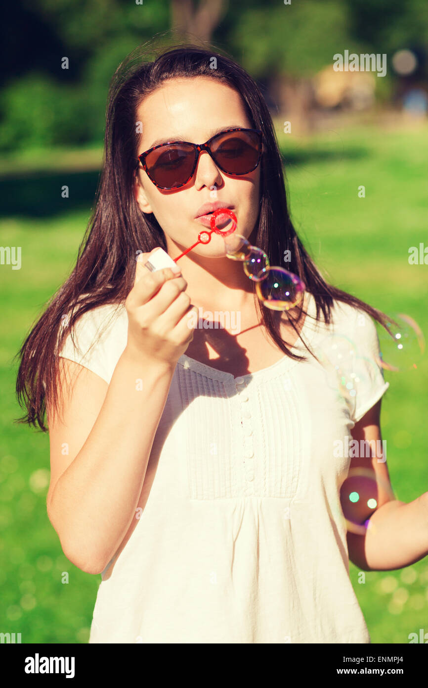 lächelndes Mädchen mit Seifenblasen im park Stockfoto