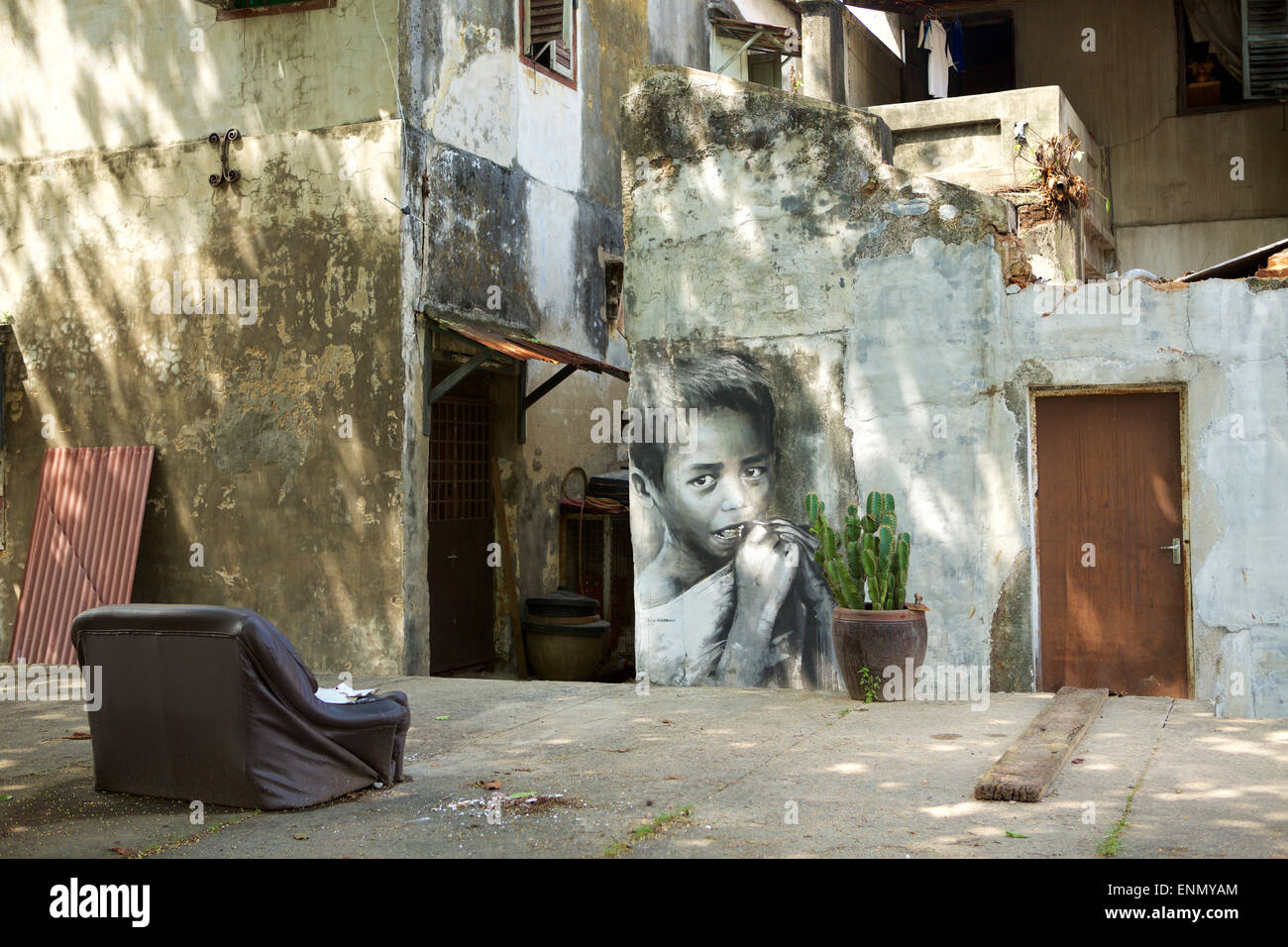 Besser als Fernsehen; sitzen Sie im alten Sofa platziert auf einer öffentlichen Straße mit Blick auf einige street-Art. Großes Bild von einem asiatischen Kind essen Stockfoto