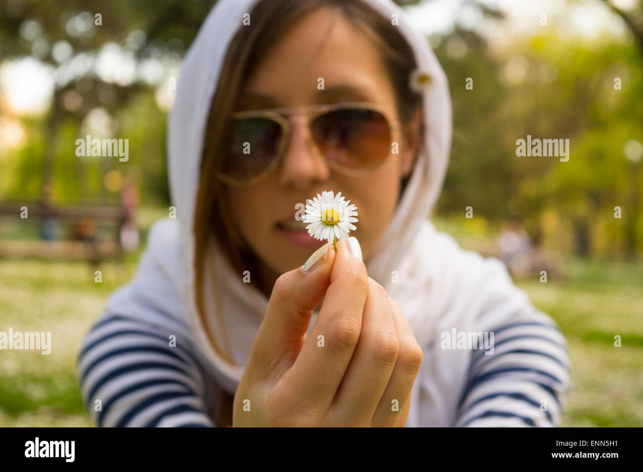 Brünette Mädchen halten Gänseblümchen im park Stockfoto