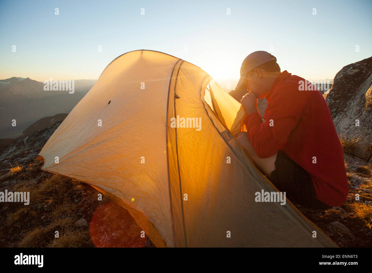 Ein Wanderer bläst seine Luft-Matratze beim Zelten auf dem Gipfel des Steinbrech, Pemberton, Kanada. Stockfoto