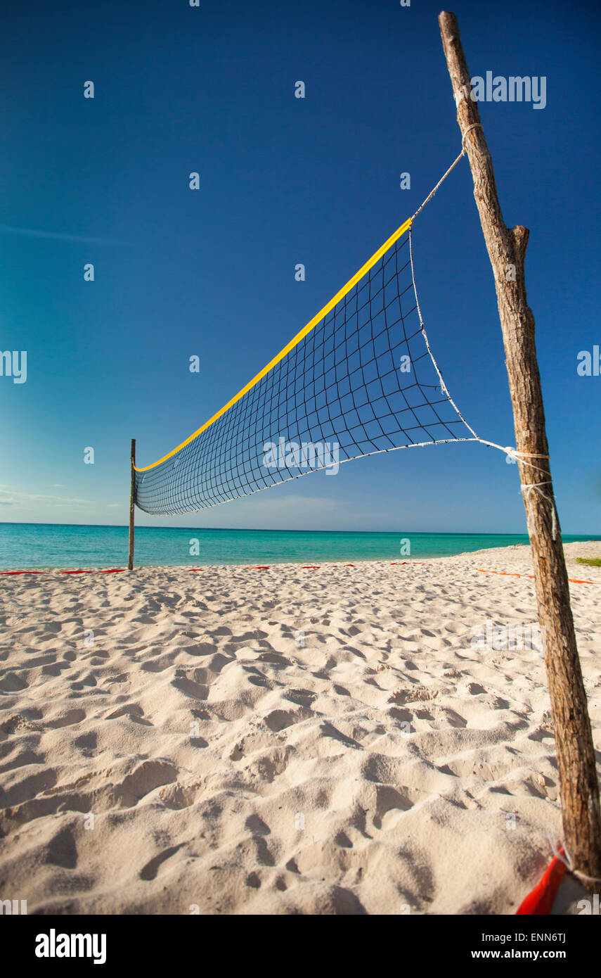 Zwei grobe Stöcke halten ein Beach-Volleyball Netz eingerichtet, neben dem Meer am Strand von Playa La Jaula, Cayo Coco, Kuba. Stockfoto