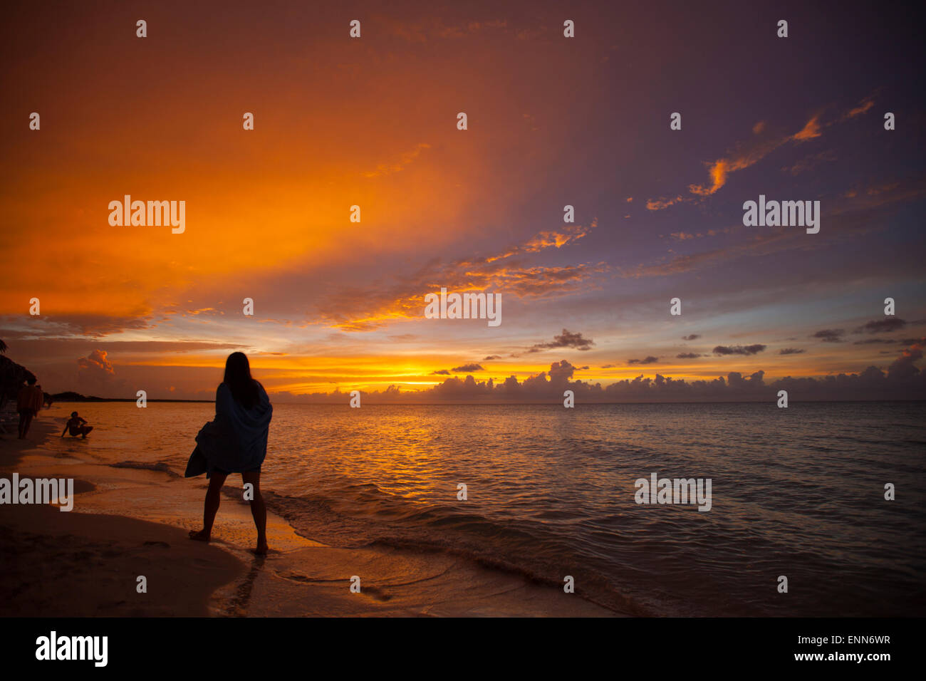 Eine Silhouette junge Frau geht am Strand kurz nach Sonnenuntergang in Cayo Coco, Kuba. Stockfoto