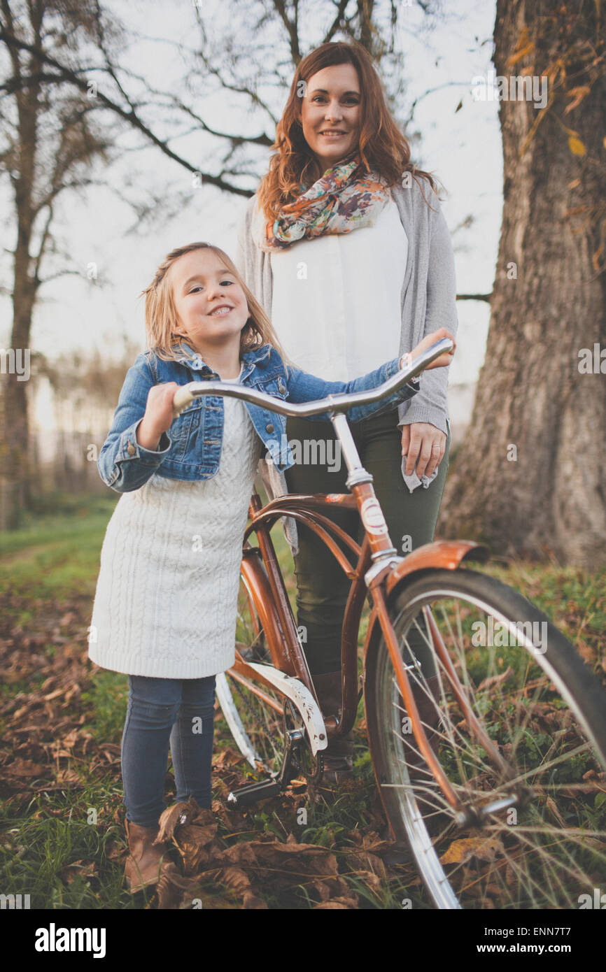 Eine Mutter und Tochter posieren mit einem altmodischen Fahrrad. Stockfoto