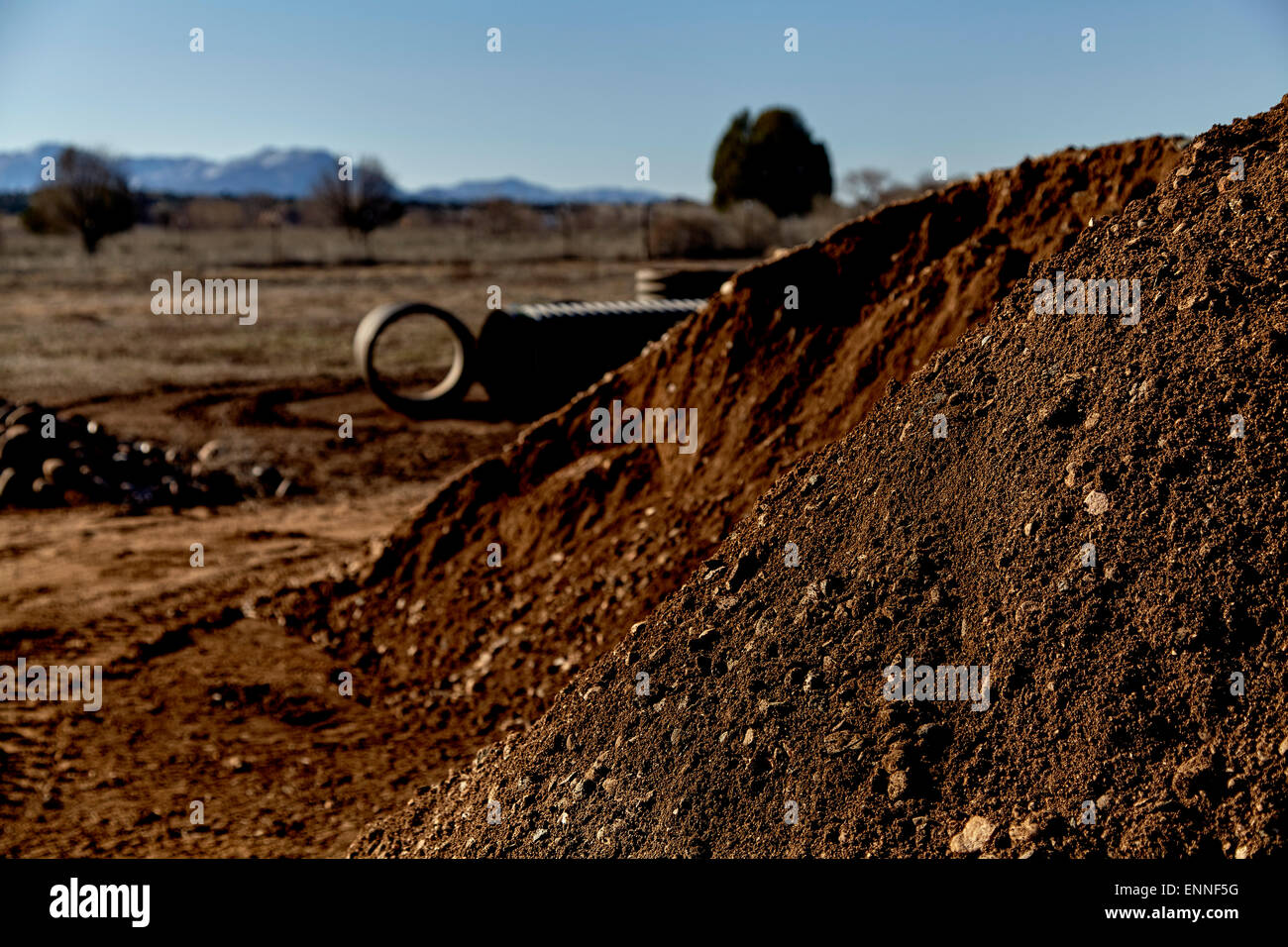 Haufen von Schmutz mit Abflussrohre und Felsen im Hintergrund Stockfoto