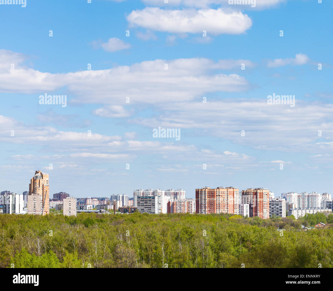 blauer Himmel mit weißen Wolken über Stadt und grünen Wäldern in sonniger Frühlingstag Stockfoto