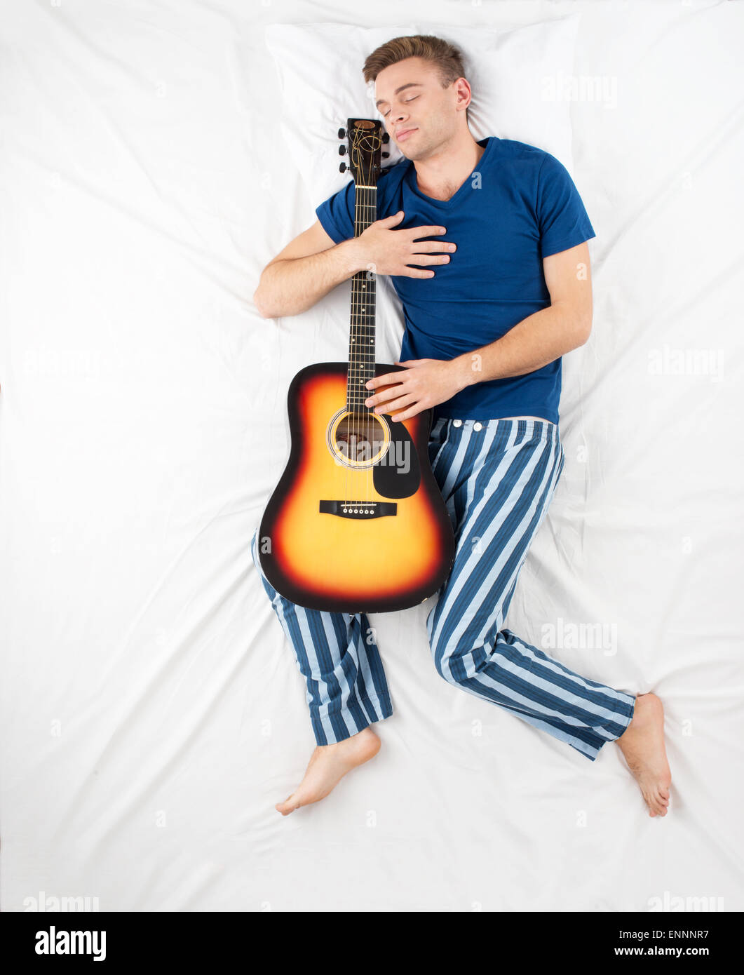 Mann schläft mit einer Gitarre Stockfoto