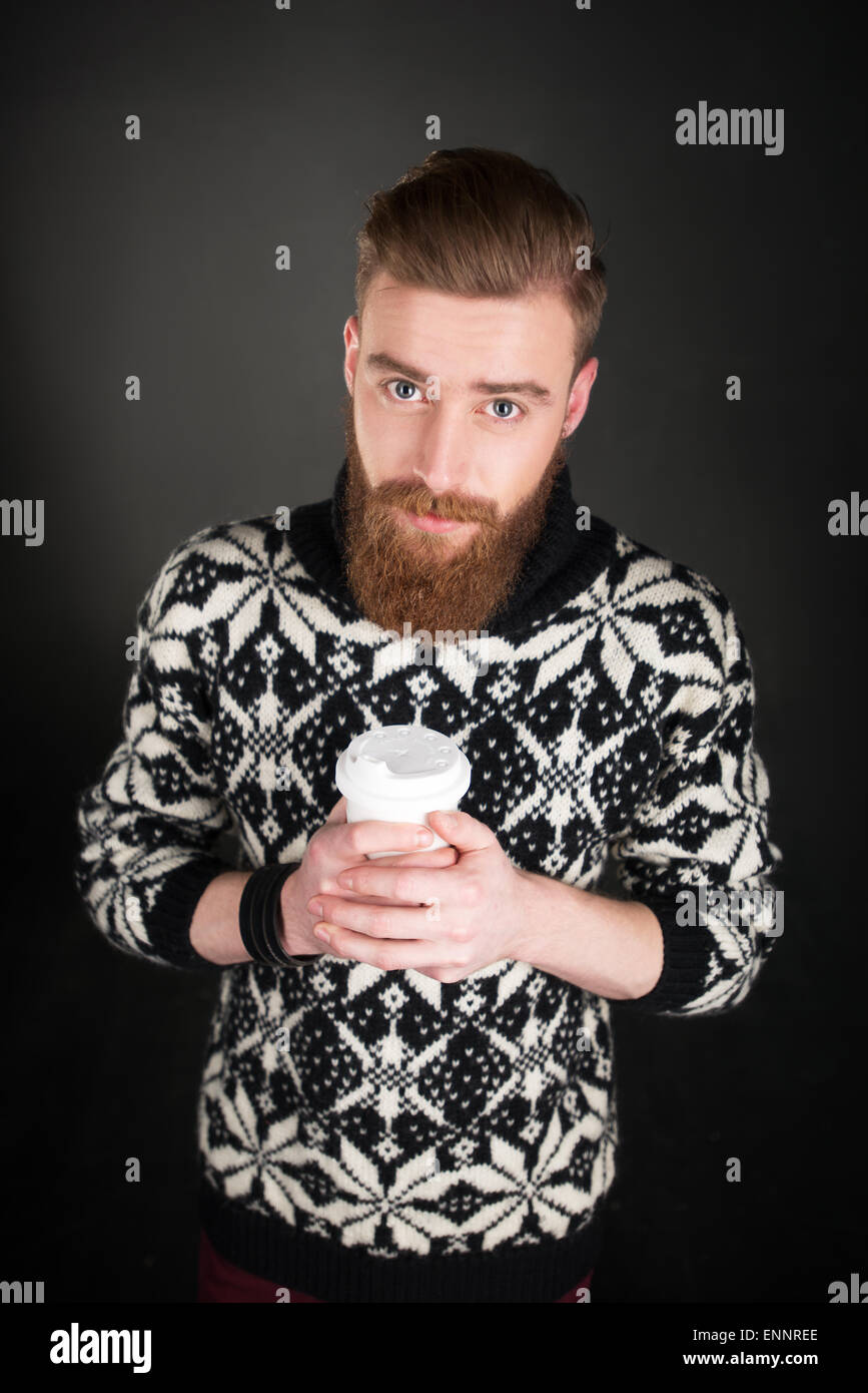 Junger Mann mit Bart hält eine Tasse Kaffee Stockfoto