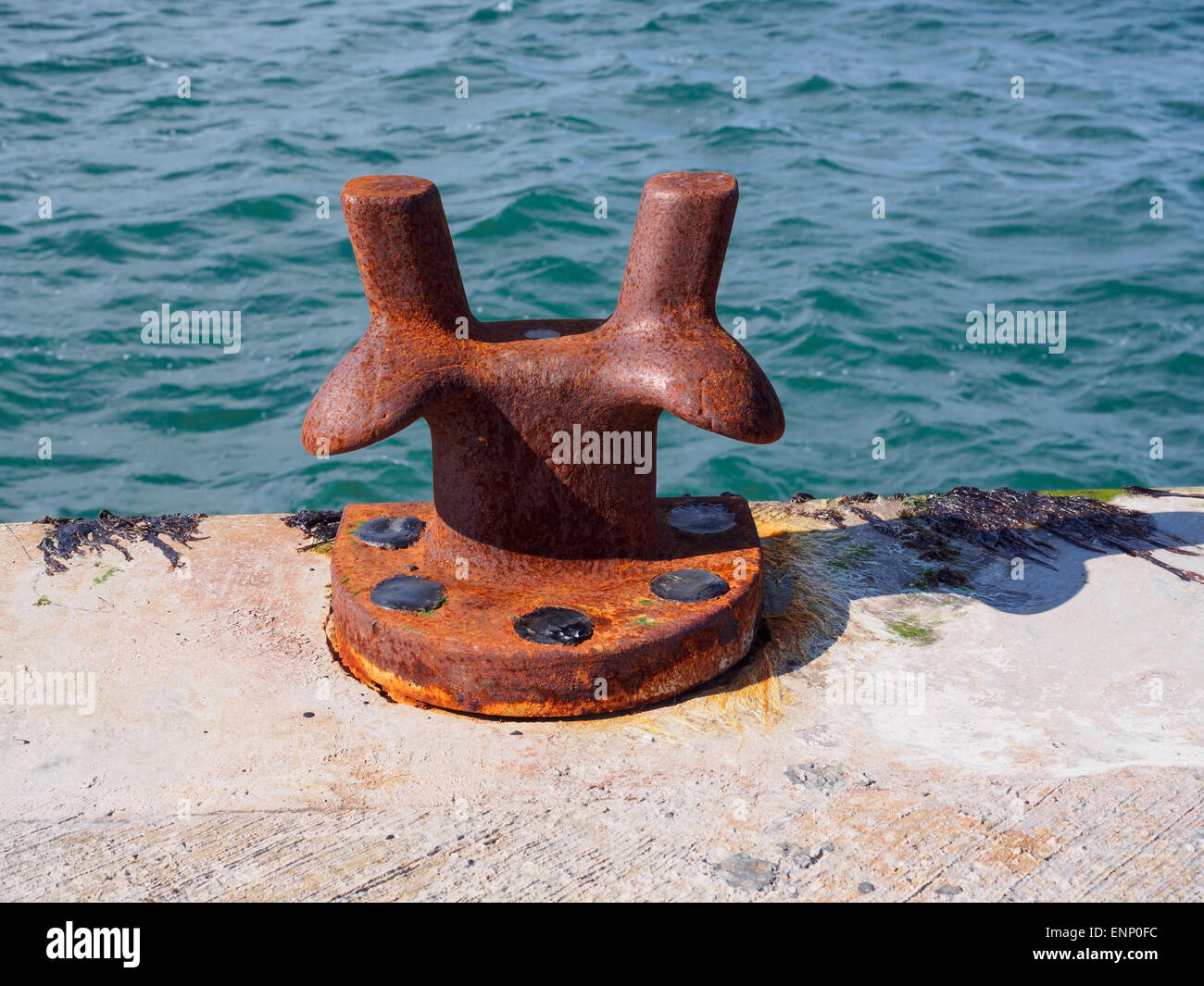 Ein rostiges Eisen Poller zum Festmachen von Schiffen, auf einem Pier in Schottland. Stockfoto