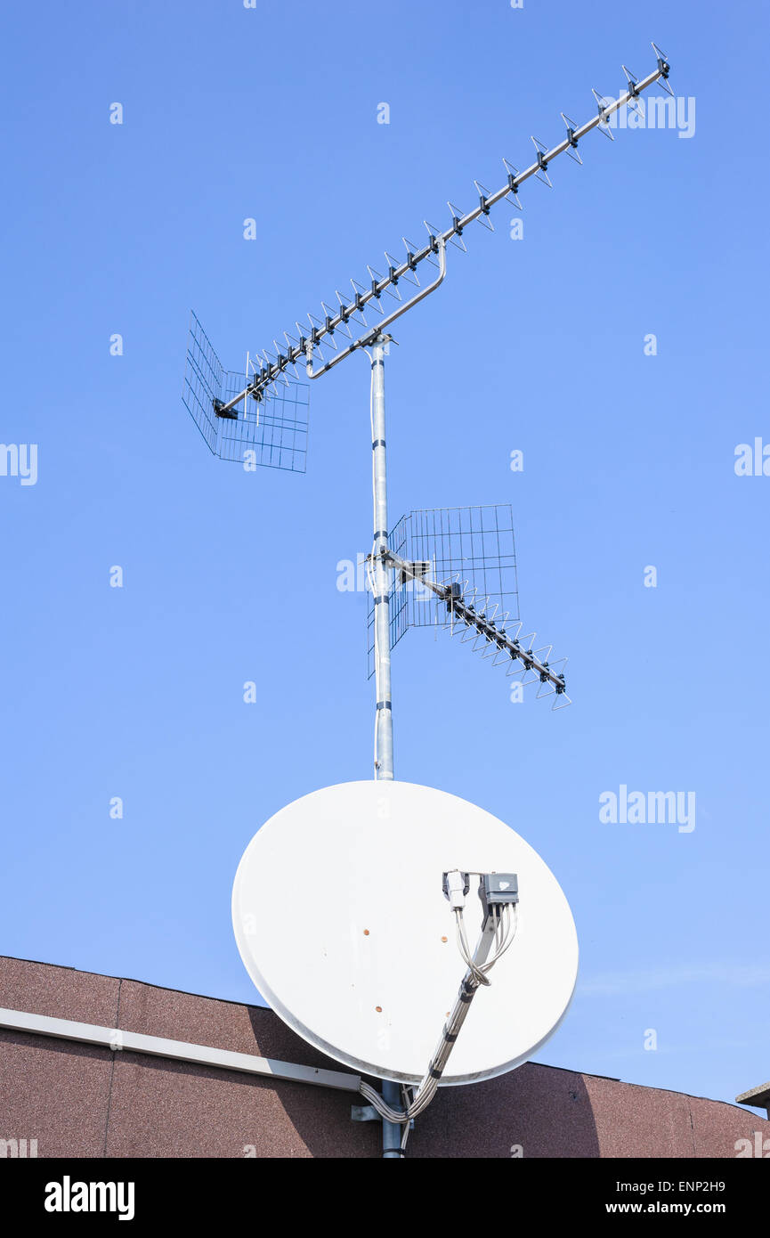 TV-Antenne und Satellitenschüssel vor blauem Himmel Stockfoto