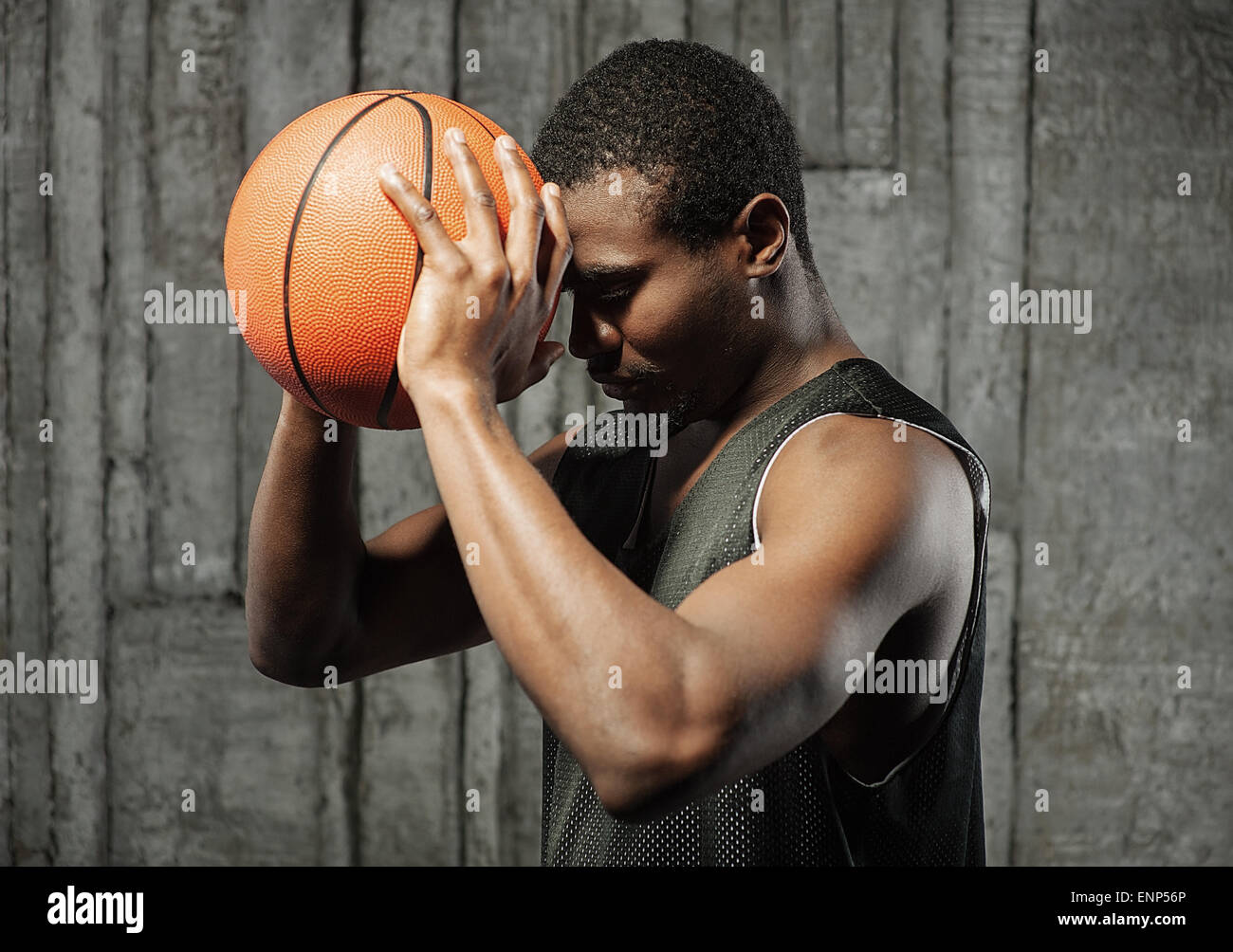 Afro-American Basketball Spieler Pressung Kugel an die Stirn Stockfoto