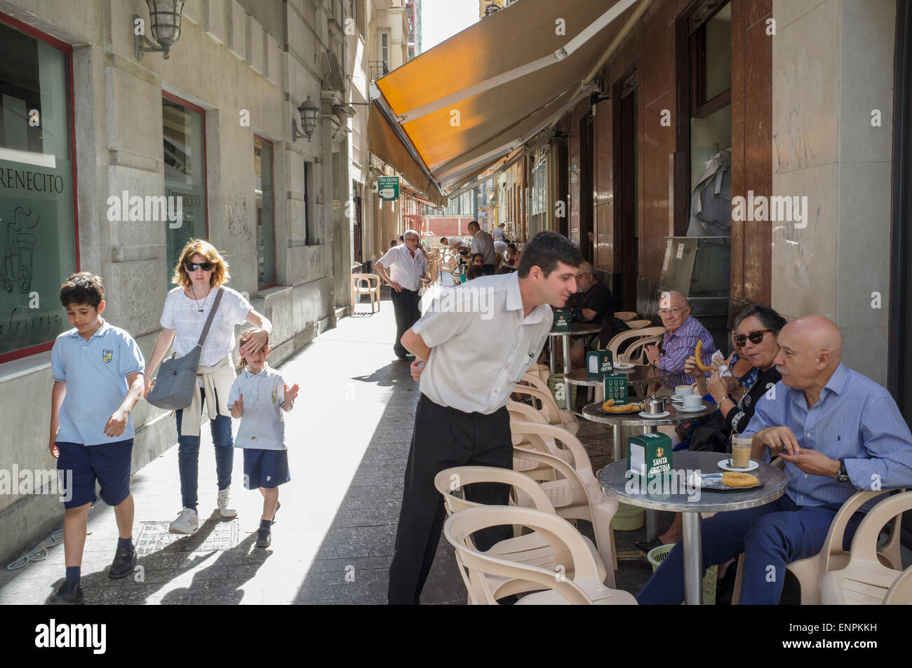 Malaga, Spanien. Menschen Essen "Churros" (typische frittierten Teig Gebäck) in ein Café mit Terrasse. Stockfoto