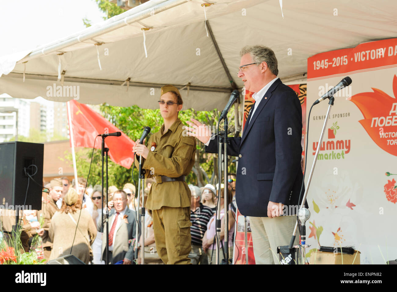 Toronto, Kanada. 9. Mai 2015. Kanadischer Politiker Mark Adler, Mitglied des House Of Commons of Canada Toronto Wahlbezirk York Centre, spricht für den offiziellen Teil der feierlichen Parade zum 70-jährigen Jubiläum der Tag des Sieges (1945-2015). Er wird vom jungen Mann in der sowjetischen militärischen Uniform ins Russische übersetzt. Tag des Sieges markiert die Kapitulation Nazi-Deutschlands auf die Sowjetunion im zweiten Weltkrieg Teil. Bildnachweis: Igor Ilyutkin/Alamy Live-Nachrichten Stockfoto