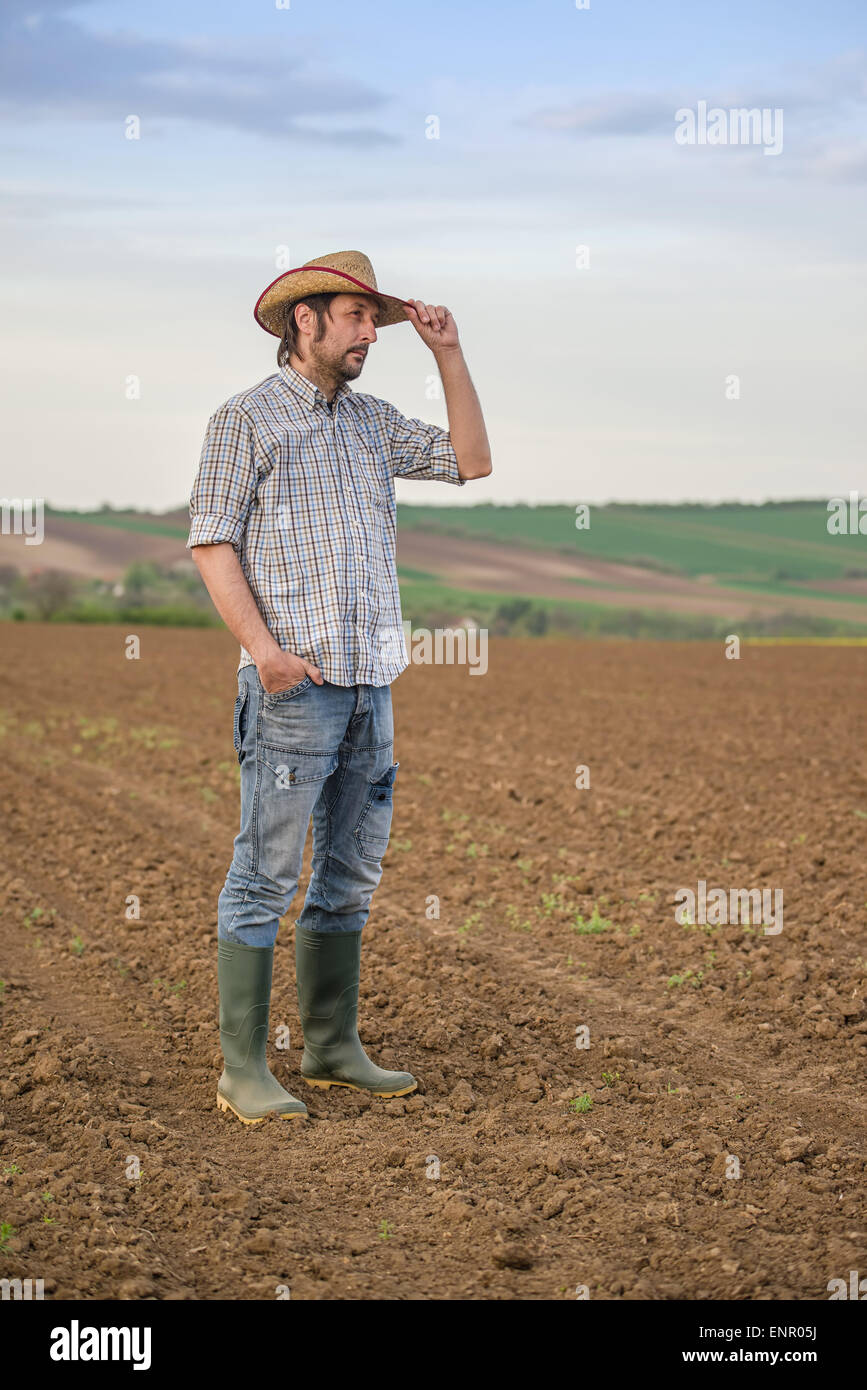 Porträt von erwachsenen männlichen Bauern auf fruchtbares Agrarland Bauernhof Boden, Blick in Ferne stehen. Stockfoto