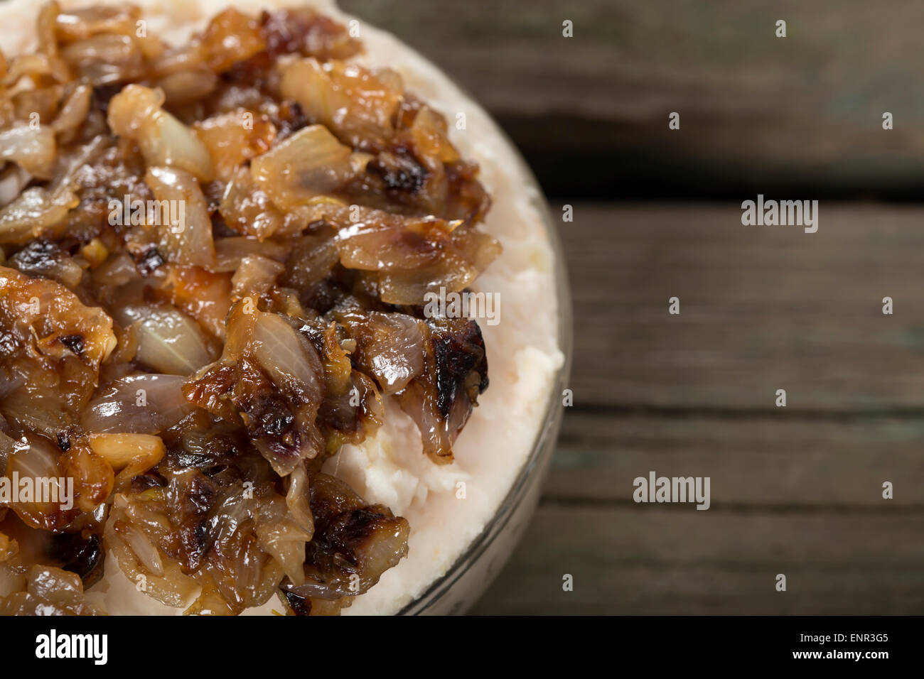 Traditionelles Essen püriert Bohnen "Iahnie" mit gebratenen Zwiebeln obendrauf in transparente Schüssel Stockfoto