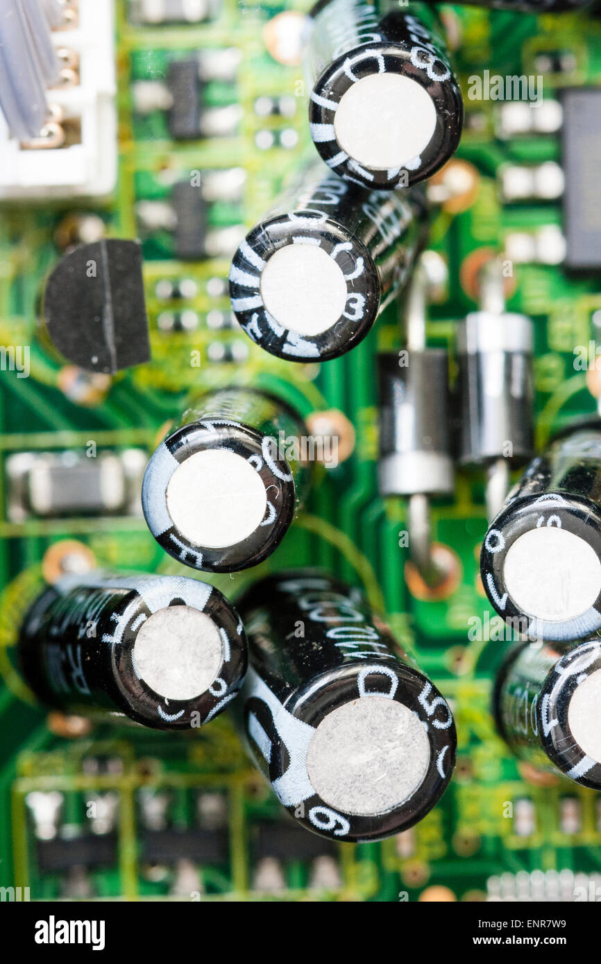 Nahaufnahme der elektronischen Druckerplatine in einem DVD-Player. Gedruckte Schaltungen, die zu schwarz beschichteten Transistoren und Widerständen führen. Stockfoto