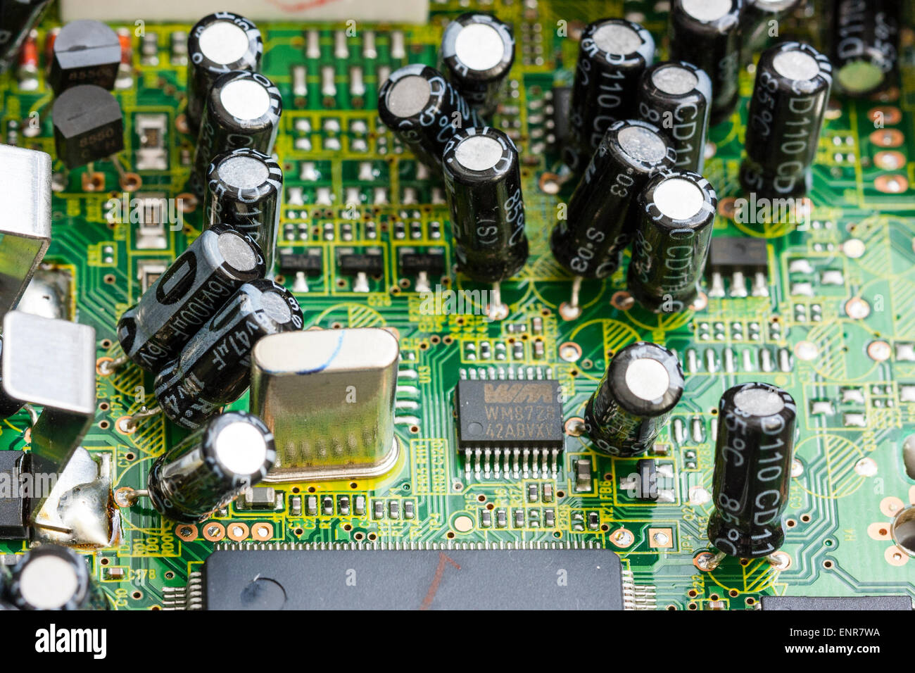 Nahaufnahme der elektronischen Druckerplatine in einem DVD-Player. Gedruckte Schaltungen, die zu schwarz beschichteten Transistoren und Widerständen führen. Stockfoto