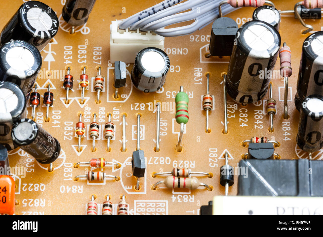 Nahaufnahme der elektronischen Druckerplatine in einem DVD-Player. Gedruckte Schaltungen, die zu schwarz beschichteten Transistoren und Widerständen führen. Stockfoto