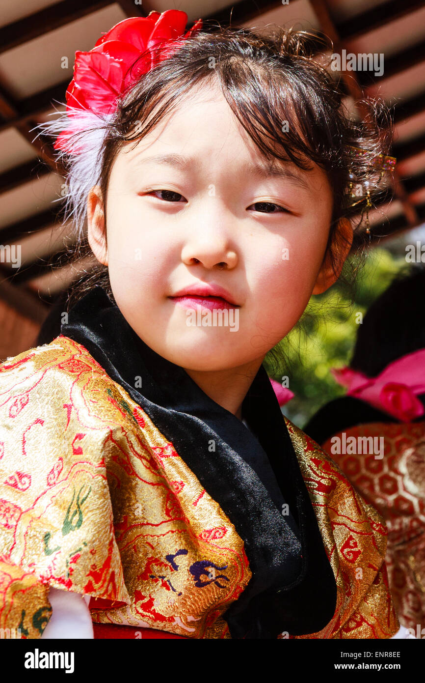 Japanisches Kind, Mädchen, 7-8 Jahre alt, in traditioneller Tracht gekleidet, und sitzend in einem Yama-Wagen auf einem Festival, wandte sich an den Betrachter zu schauen. Lächelnd. Stockfoto