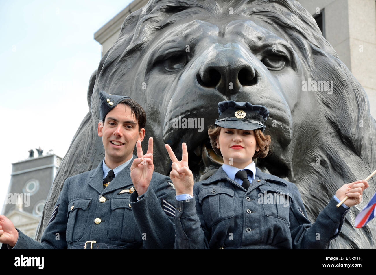 Eine Gruppe von zeitgenössisch gekleideten Reenactors reinszeniert VE Day am Trafalgar Square, London, Großbritannien zum 70. Jahrestag. RAF-Offizier, V für den Sieg Stockfoto