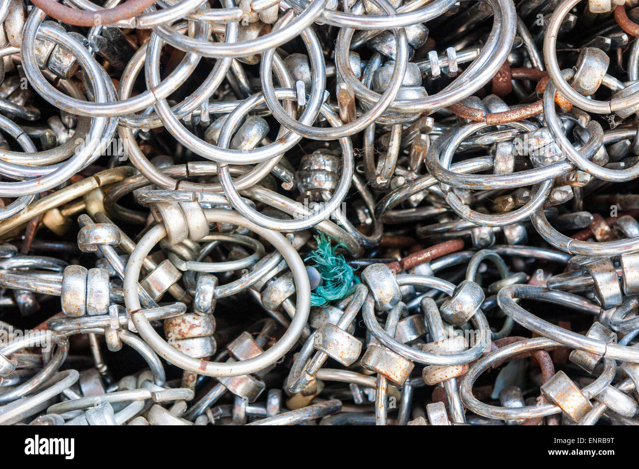 Nahaufnahme einer Masse kleiner Eisen- und Metallringe in einem großen Stapel, der an einem Schrein in Japan zurückgelassen wurde. Stockfoto