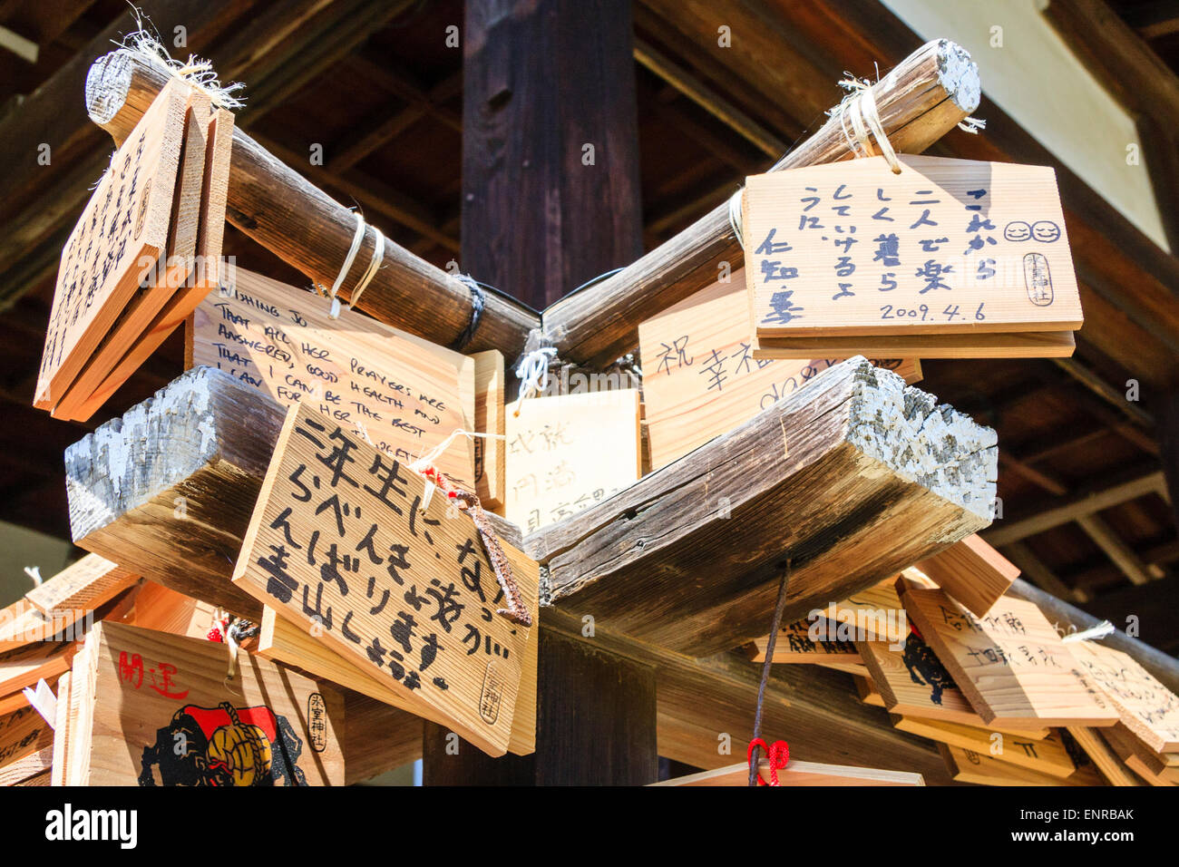 Japan, Nara, Himuro-jinja Buden-Schrein. Sonnenbeschienenen Ema-Bretter, (Wunsch, beten Tabletten), hängend von Bambus-Eckgeländer auf der Veranda des Schreinhalle. Stockfoto