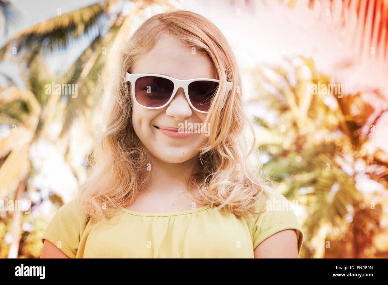 Blonde lächelnde Teenager-Mädchen in Sonnenbrillen, getönten Nahaufnahme outdoor Sommer Portrait mit Palmen auf einem bunten Hintergrund Foto mit Stockfoto