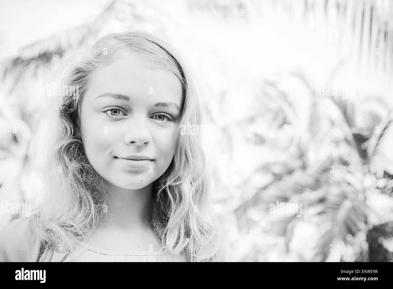 Schöne Blondine Teenager Nahaufnahme outdoor Sommer Portrait mit Palmen auf einem Hintergrund, Retro-Stil Monochrom Foto Filter ef Stockfoto