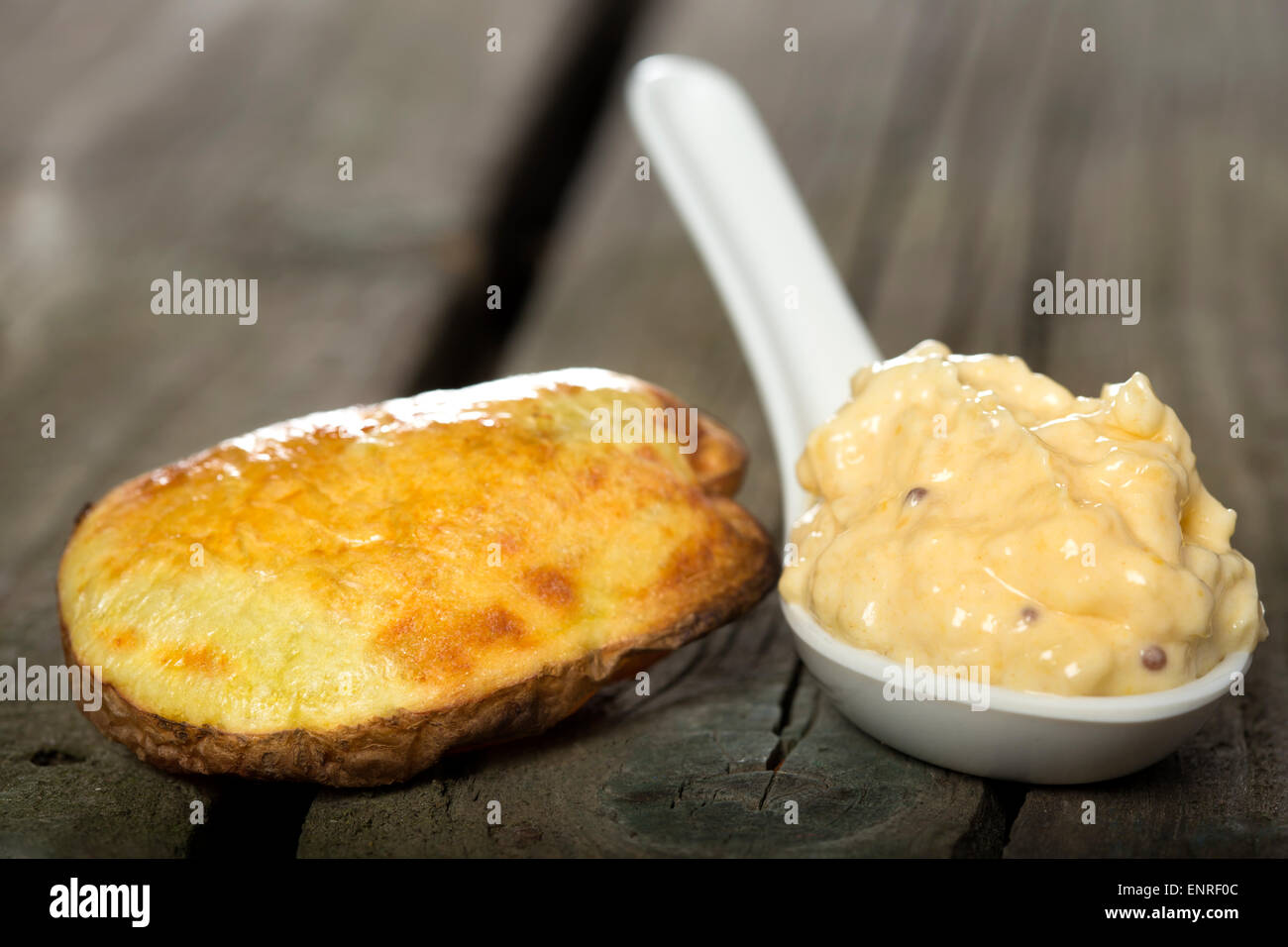 Gebackene Kartoffel mit Knoblauch-Sauce über rustikale Holz Hintergrund Stockfoto