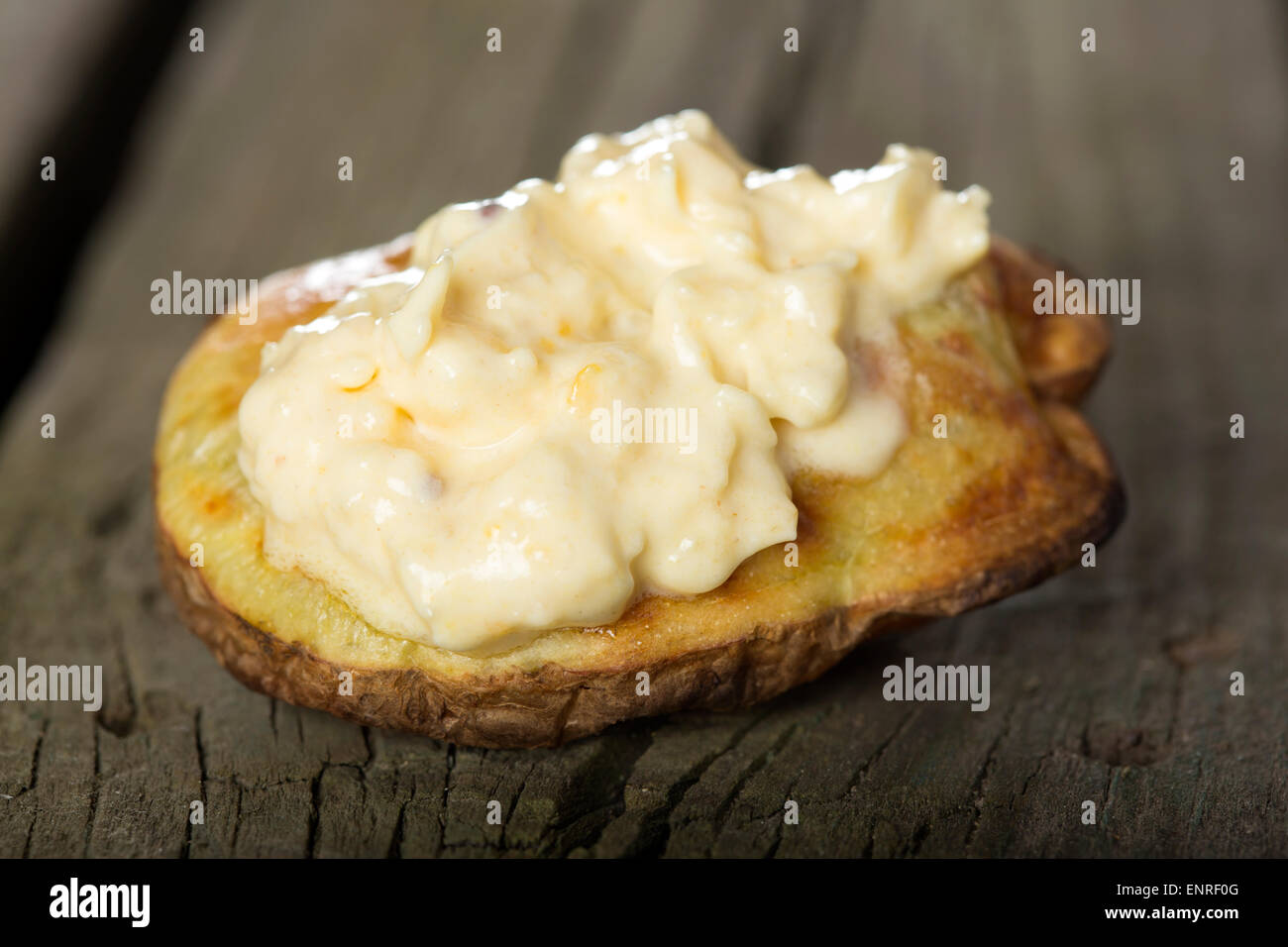 Gebackene Kartoffel mit Knoblauch-Sauce über rustikale Holz Hintergrund Stockfoto