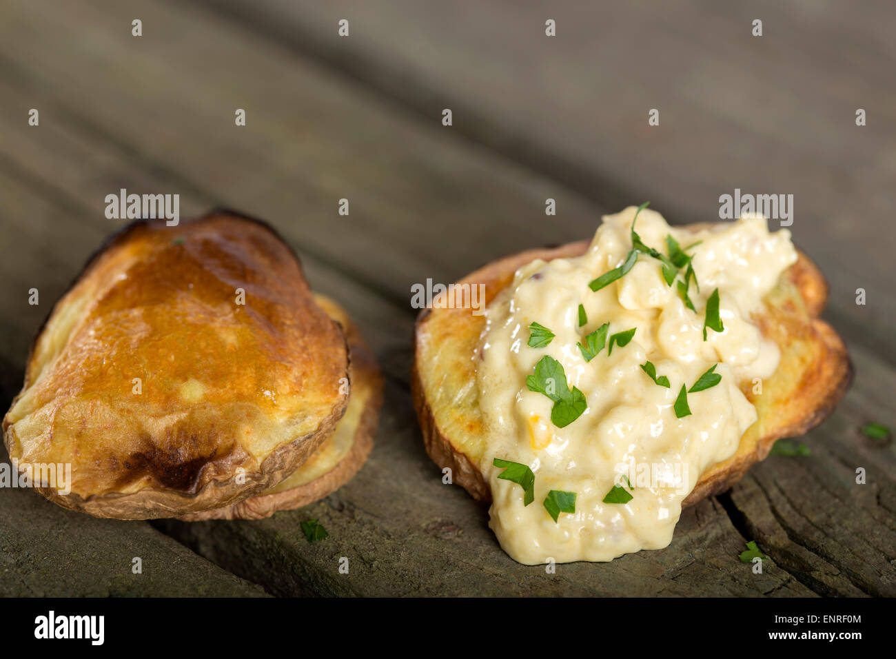 Gebackene Kartoffeln mit Knoblauch-Sauce über rustikale Holz Hintergrund Stockfoto