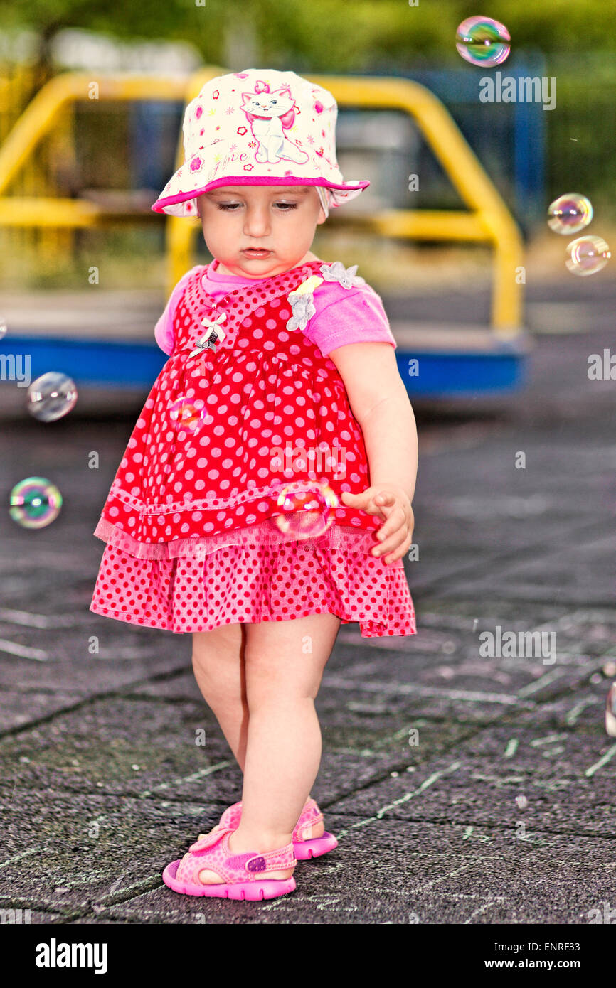 Ein hübsches kleines Mädchen mit weißem Hut Spaß mit Seifenblasen Stockfoto