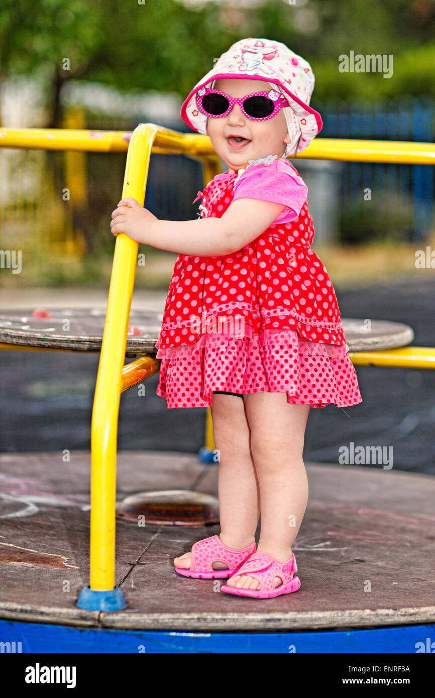 Ein hübsches kleines Mädchen mit rosa Brille und weißen Hut Spaß Stockfoto