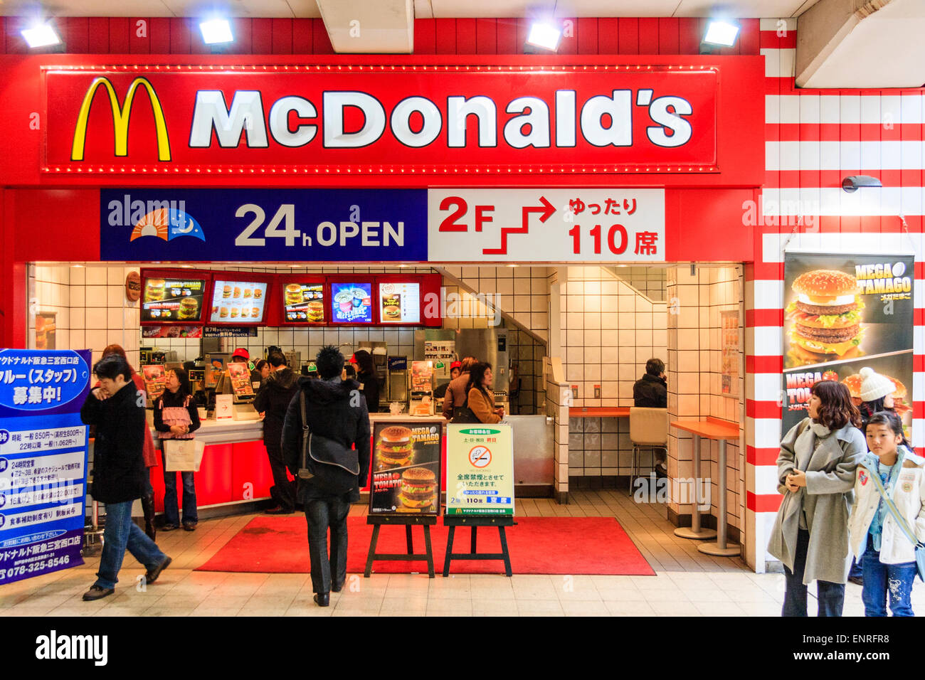 Kleines McDonald-Outlet am Bahnhof Sannomiya, Japan. Burger-Schalter vor dem Hotel, die auf Bestellungen warten, über dem Schild für 110 Personen. Stockfoto