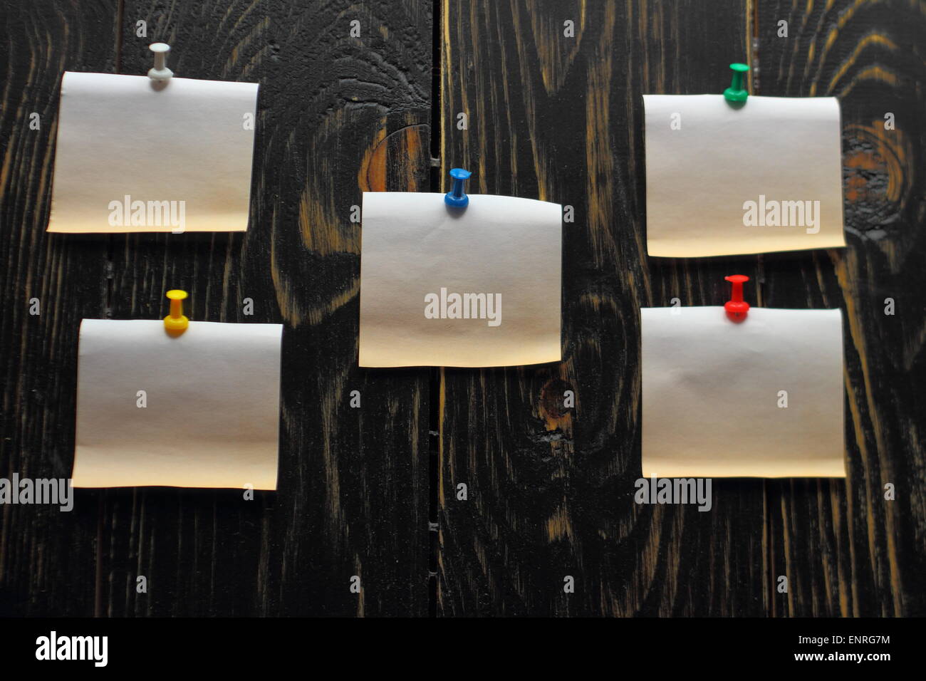 auf einem Holzbrett befestigt fünf kleine Papierstückchen Stockfoto