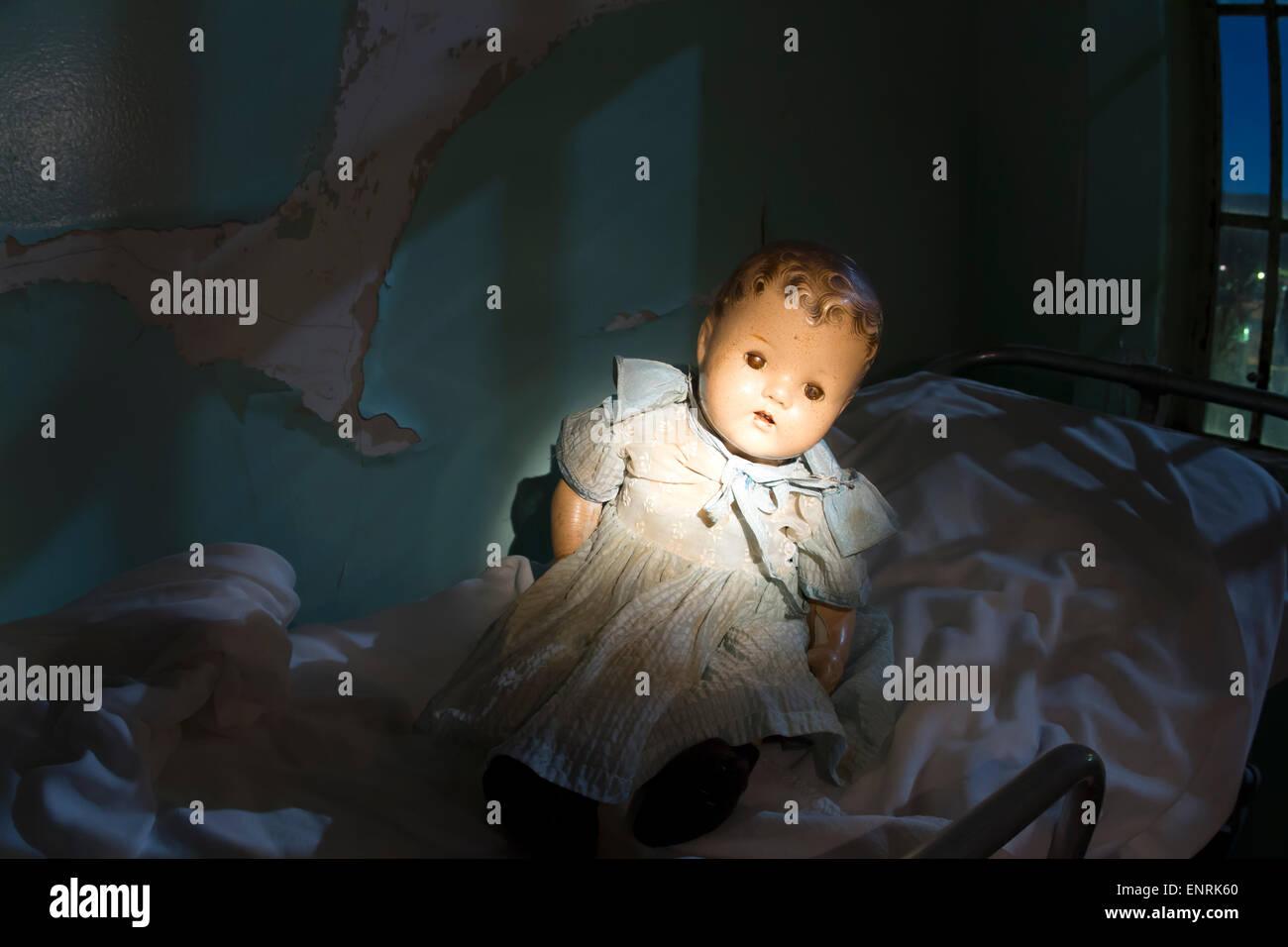Puppe sitzen am Bett von verlassenen Gebäude vernachlässigt. Stockfoto
