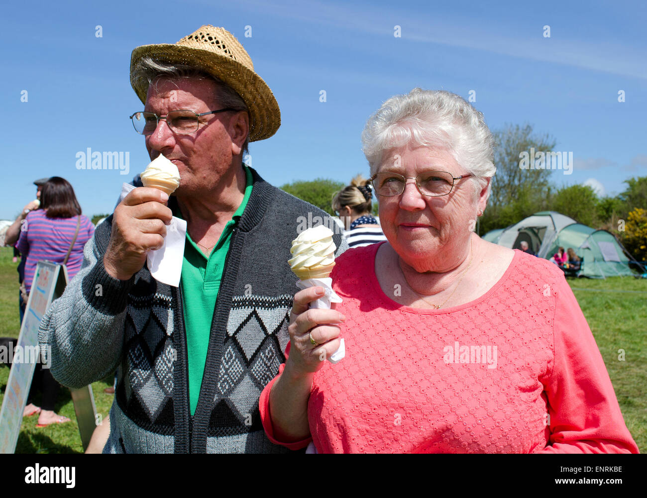ein älteres Paar genießen ein Eis auf einem Jahrmarkt in Cornwall, Großbritannien Stockfoto