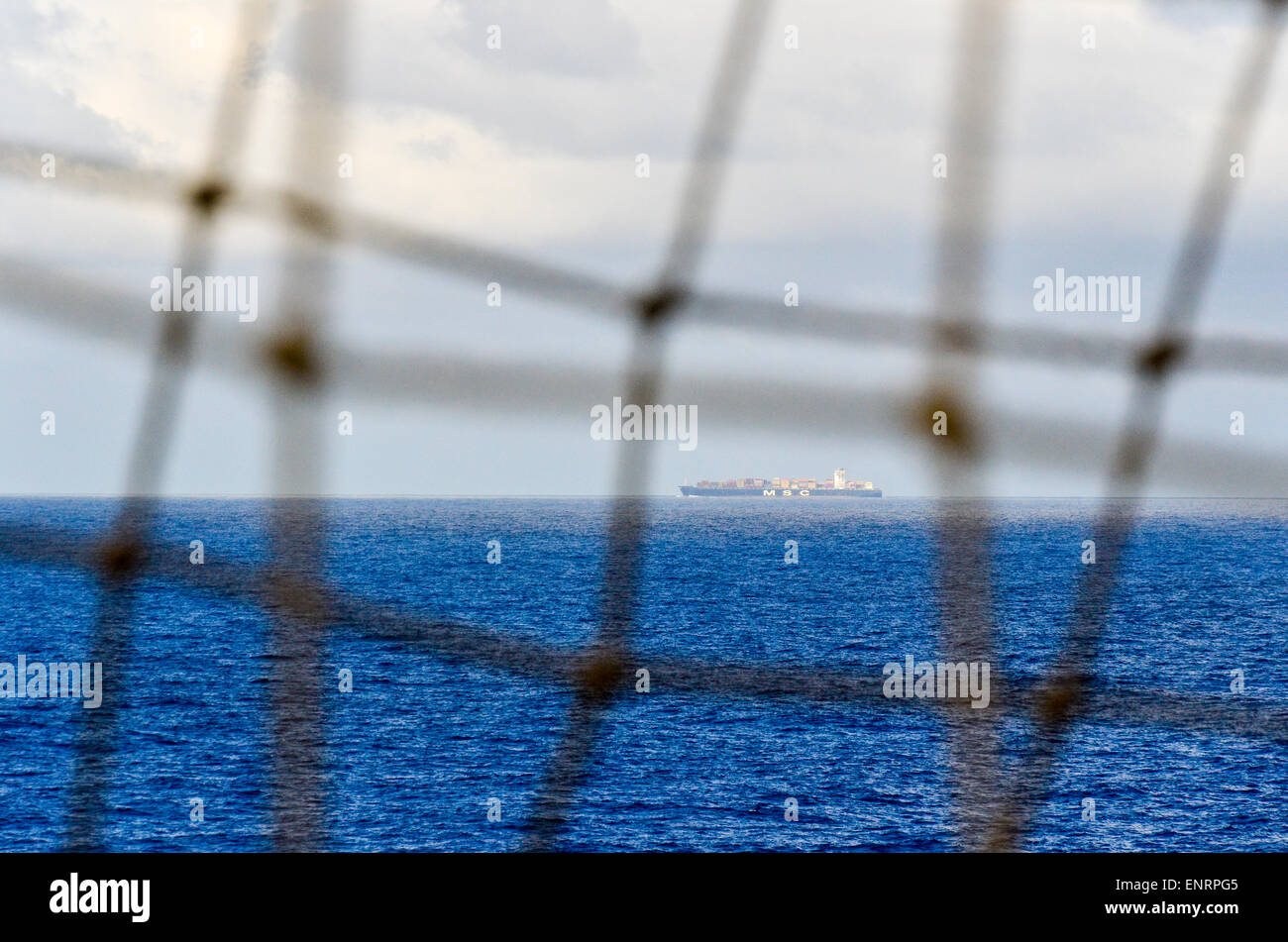 Containerschiff im Atlantischen Ozean gesehen durch ein Netz Stockfoto