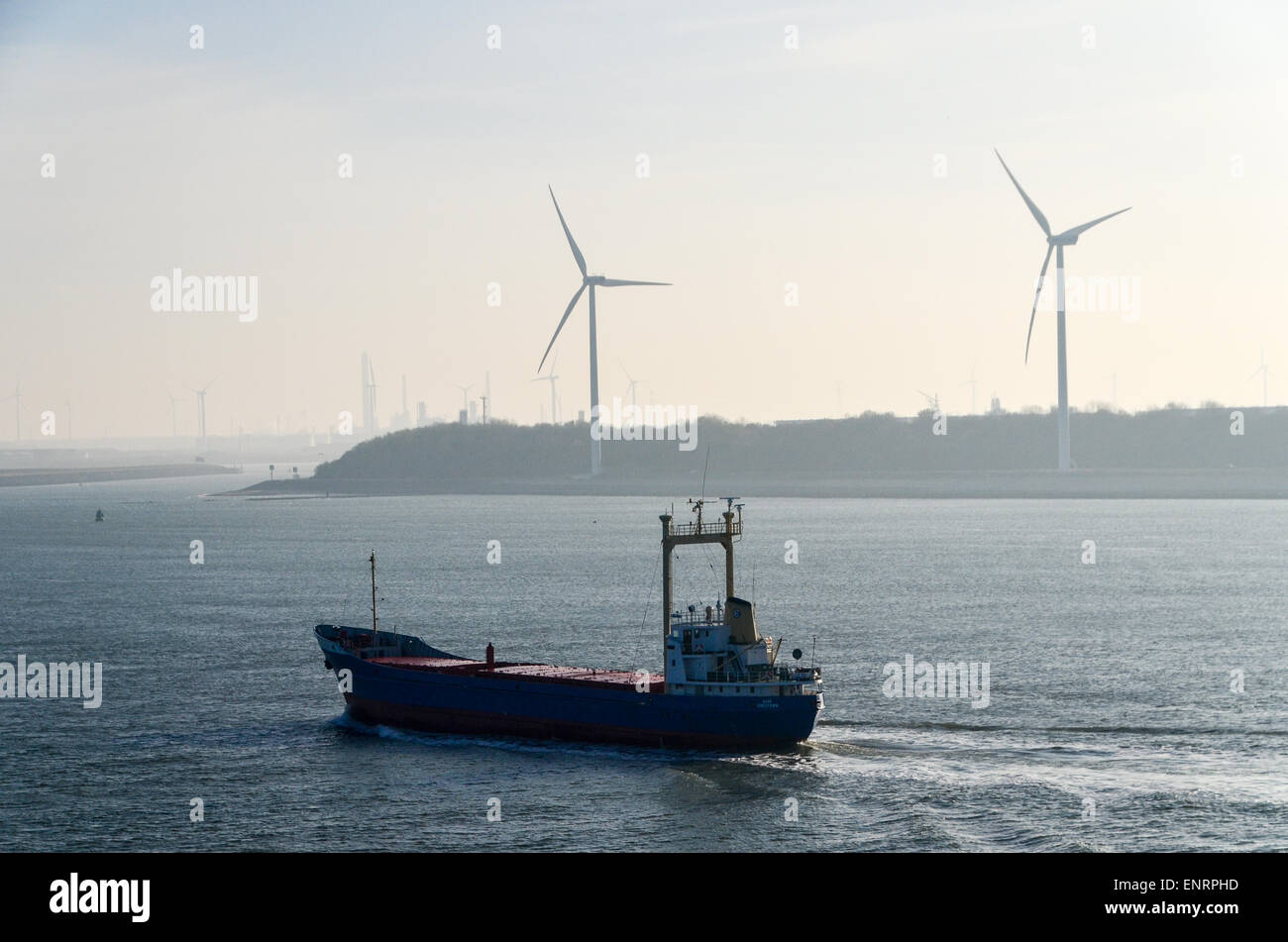 Ein Frachtschiff vorbei an Windmühlen in den Hafen von Rotterdam, Niederlande Stockfoto