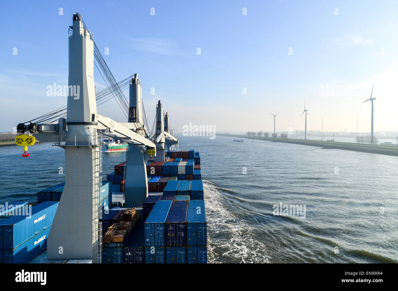 Ein Frachtschiff vorbei an Windmühlen in den Hafen von Rotterdam, Niederlande Stockfoto