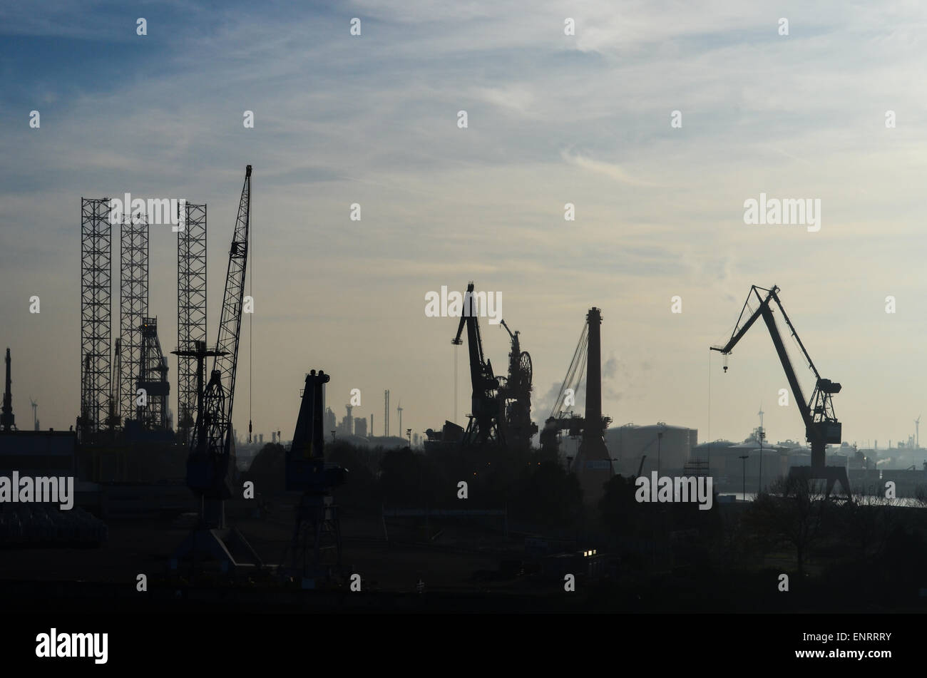 Silhouetten von Kränen und Werft im Gegenlicht, Hafen von Rotterdam, Niederlande Stockfoto