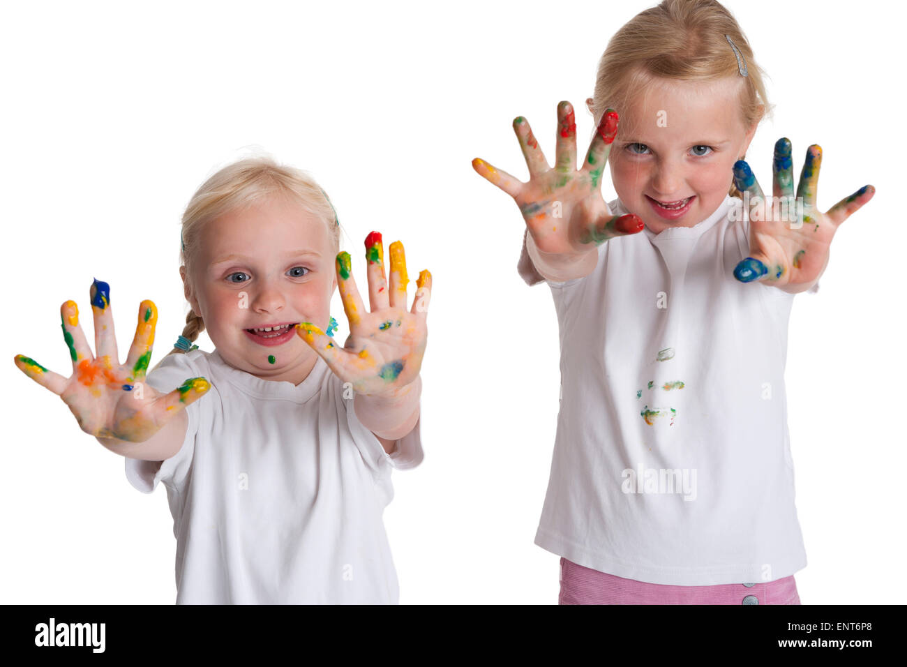 Zwei blonde Schwestern zeigen ihre Finger mit viel Farbe auf weißem Hintergrund Stockfoto