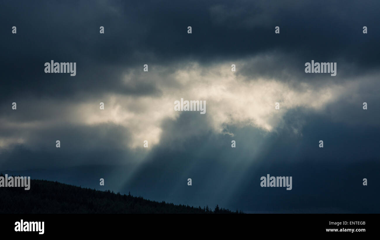 Sonnenstrahlen brechen durch die Wolken in einem dramatischen stürmischen Himmel, Großbritannien Stockfoto