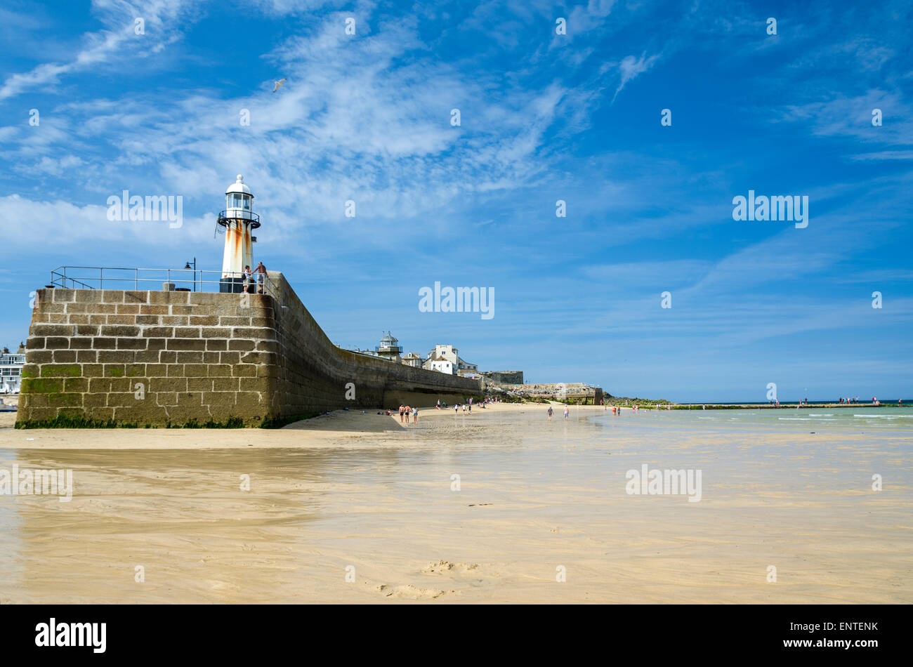 Der Hafenmauer mit seinem Leuchtturm in St Ives in Cornwall. Bei Ebbe wird des Hafens Strand und es erstreckt sich auf das Meer. Stockfoto