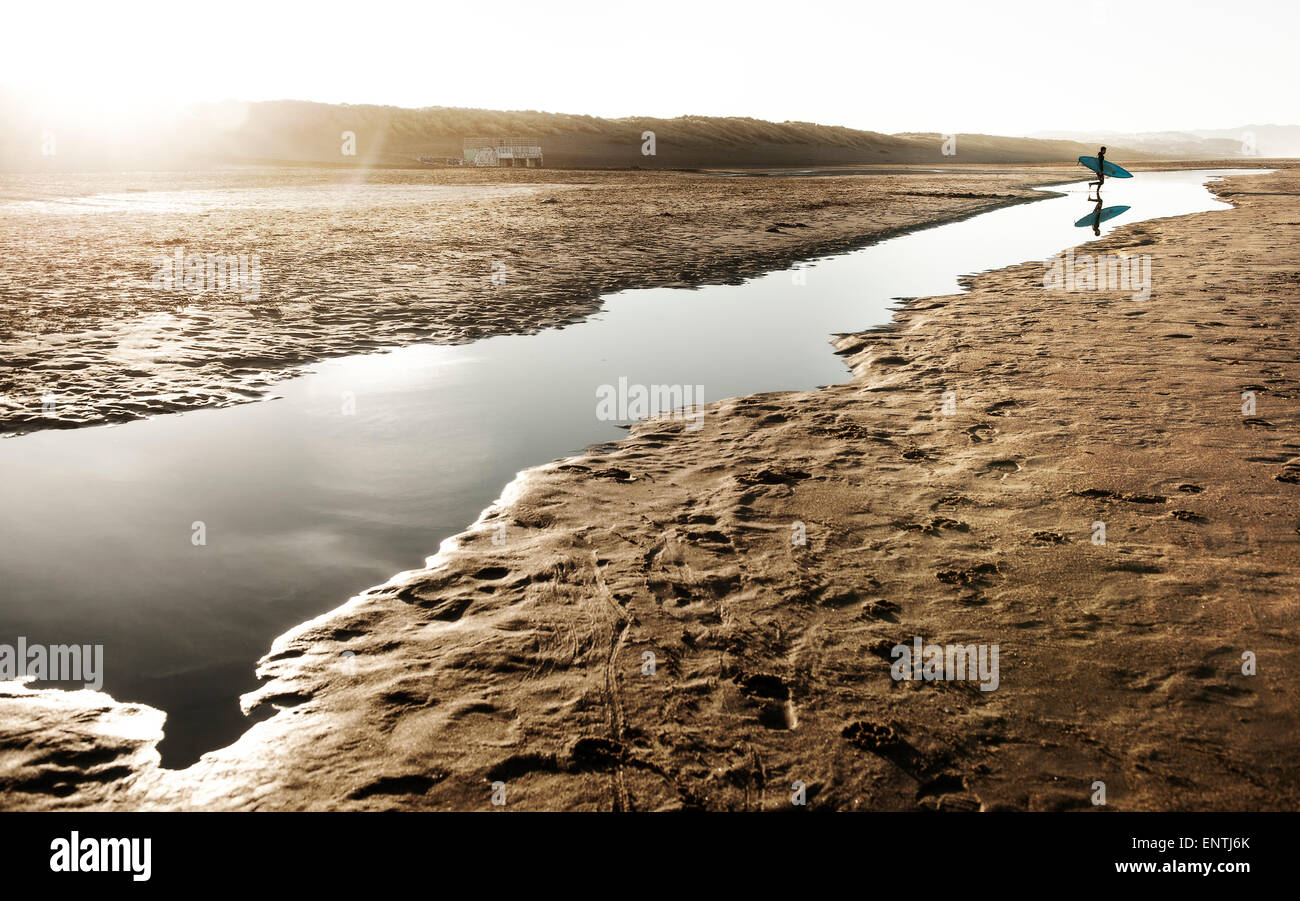 Surfer Reflexion während Crossong Hochwasser am Ocean beach Stockfoto