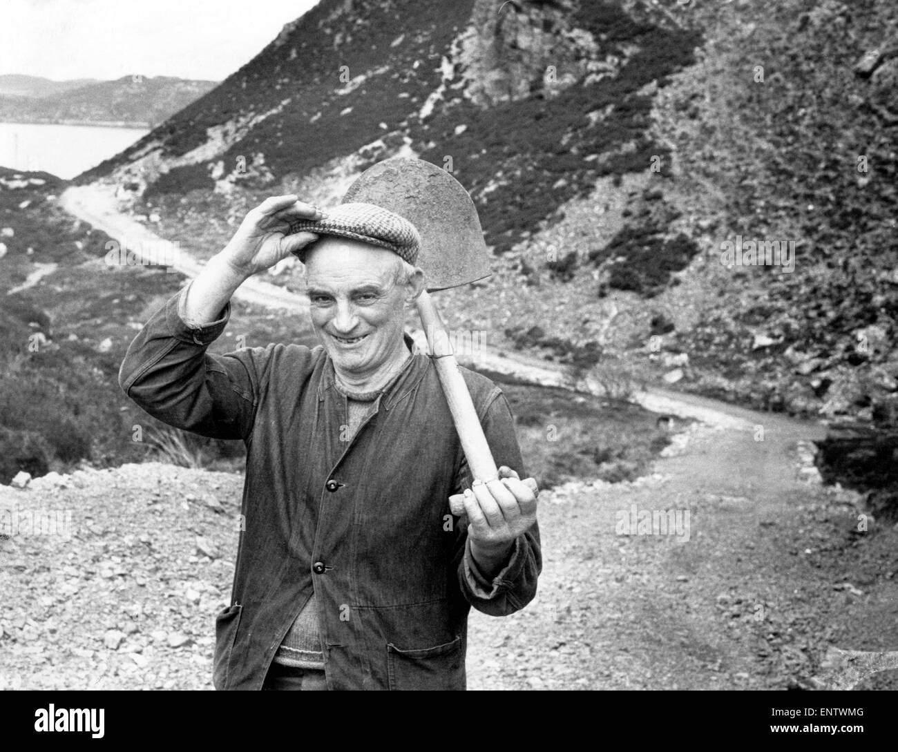 Crofter, Callum MacLeod, 63, schultert seine Schaufel, nachdem ein weiterer Tag auf der Straße... seinen eigenen Weg, arbeiten 29. April 1973. Es schlängelt sich zweieinhalb Meilen durch zwei Linien der Hügel, über zwei Torfmoore und Röcke den Rand einer Klippe 250 Fuß. Callum hat diese enorme Aufgabe mit nur einer Schaufel, einem Grabhügel und eine Abholung in Angriff genommen. Die Geschichte von Callums Straße begann im Jahre 1925 er seine Kampagne begann zu Inverness County Council, eine Straße zu dem Dorf Arnis auf Raasay zu bauen. Der Rat abgelehnt, und so ging er es allein. Aufbau der Straße einen Schritt zu einer Zeit über mehrere Jahrzehnte Stockfoto